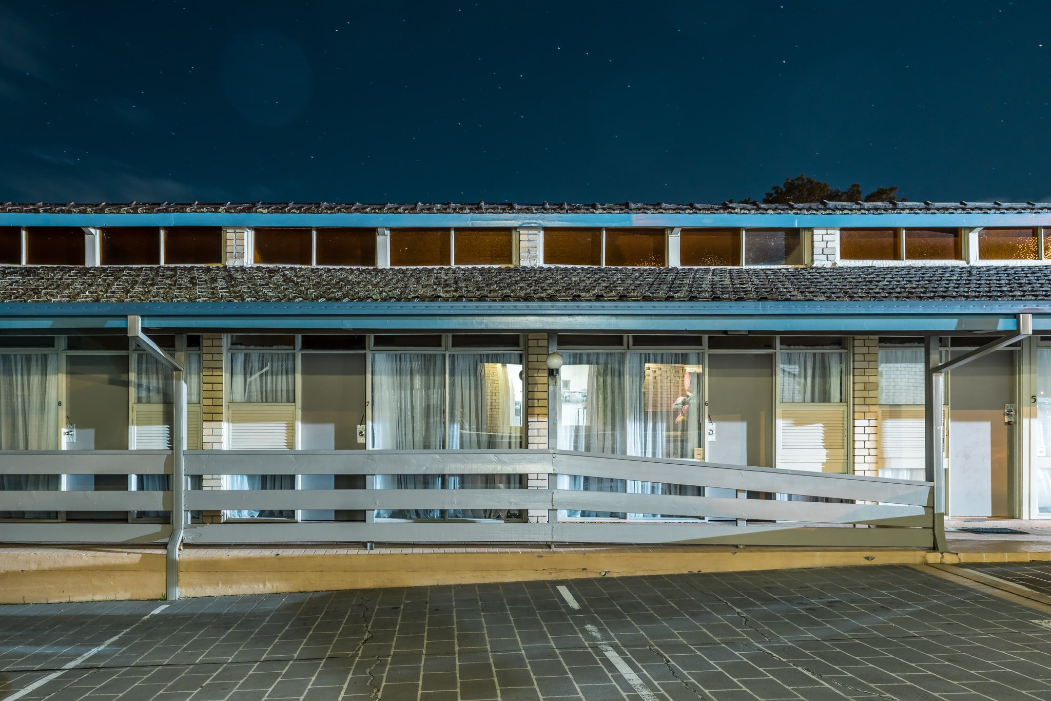 Jetty Motel at Hotel Motel 101, a single-storey motel block stretches across the frame under a deep night sky.