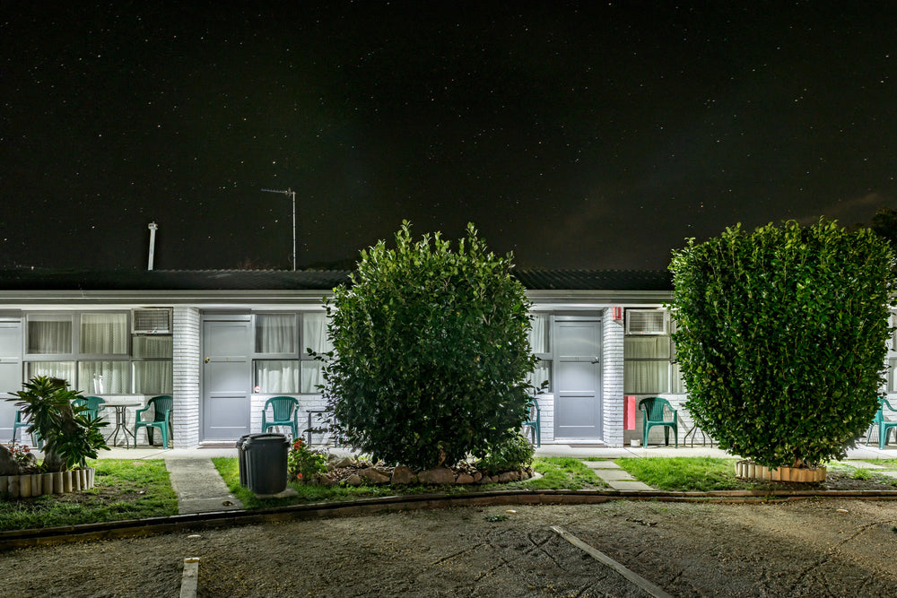 Mittagong Motel at Hotel Motel 101, two white-painted brick units sit side by side under a dark sky thick with stars.