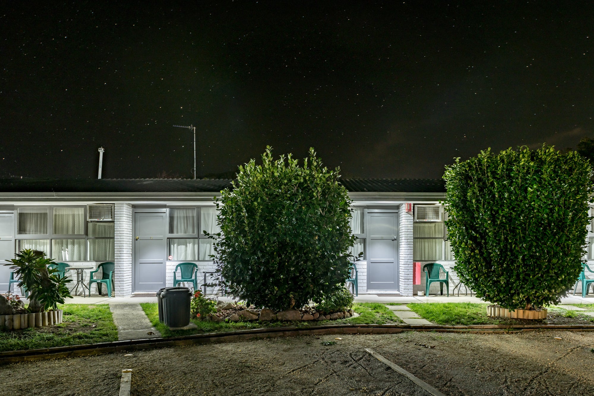 Mittagong Motel at Hotel Motel 101, two white-painted brick units sit side by side under a dark sky thick with stars.