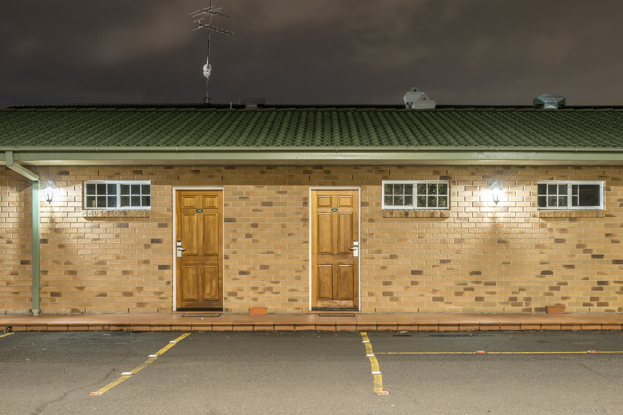Quality Inn at Hotel Motel 101, two timber doors sit side by side in a brown brick facade.