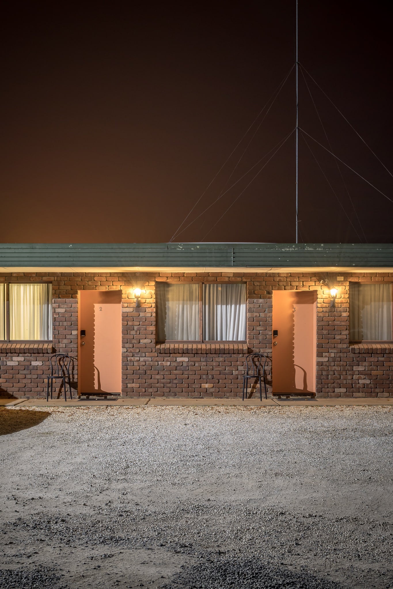 Robertson Country Motel, Robertson at Hotel Motel 101, a gravel car park in front of two motel rooms with a tall aerial.