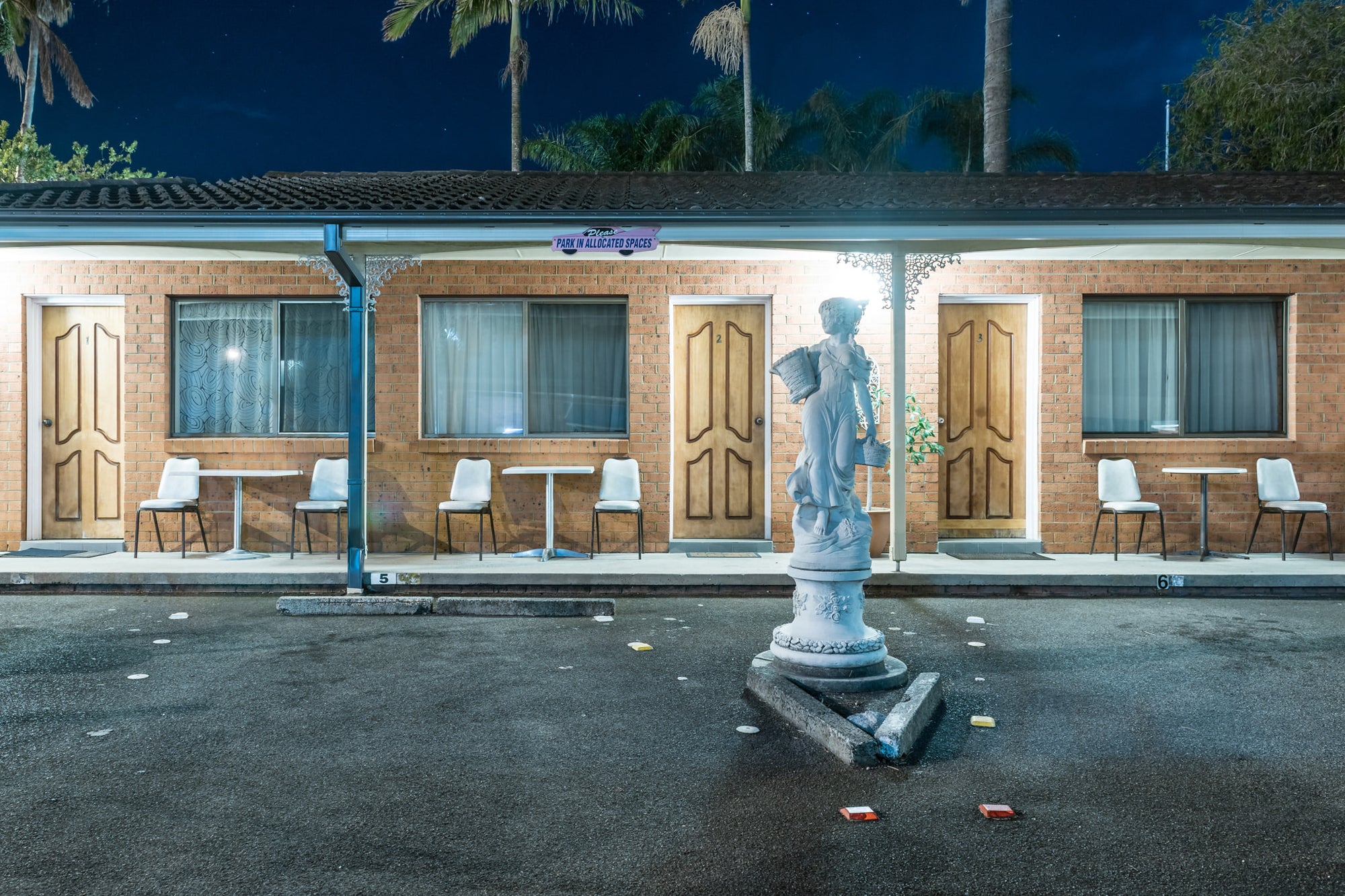 Sapphire Palms Motel, The Entrance at Hotel Motel 101, a statue stands in the motel carpark with palm trees rising behind.