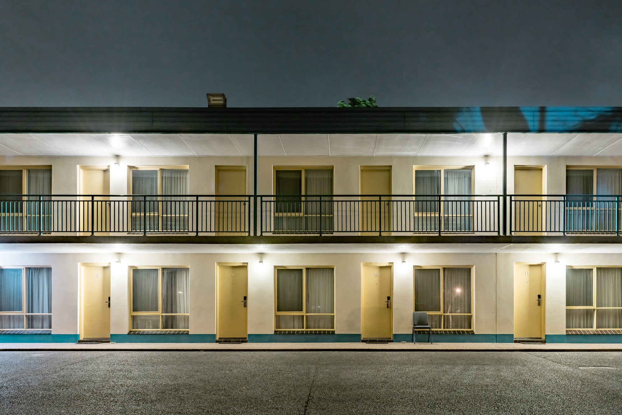 Shellharbour Resort at Hotel Motel 101, two storeys of rendered concrete and cream-painted doors face an empty car park.