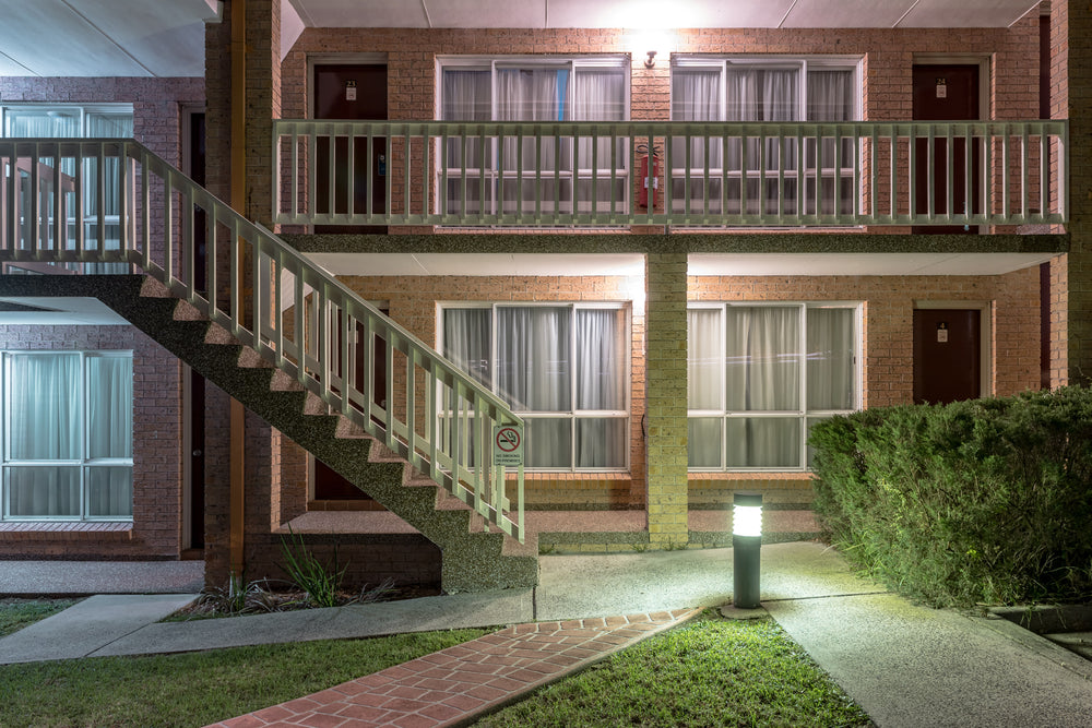 Sutherland Motel at Hotel Motel 101, two storeys of brown brick face an empty courtyard.
