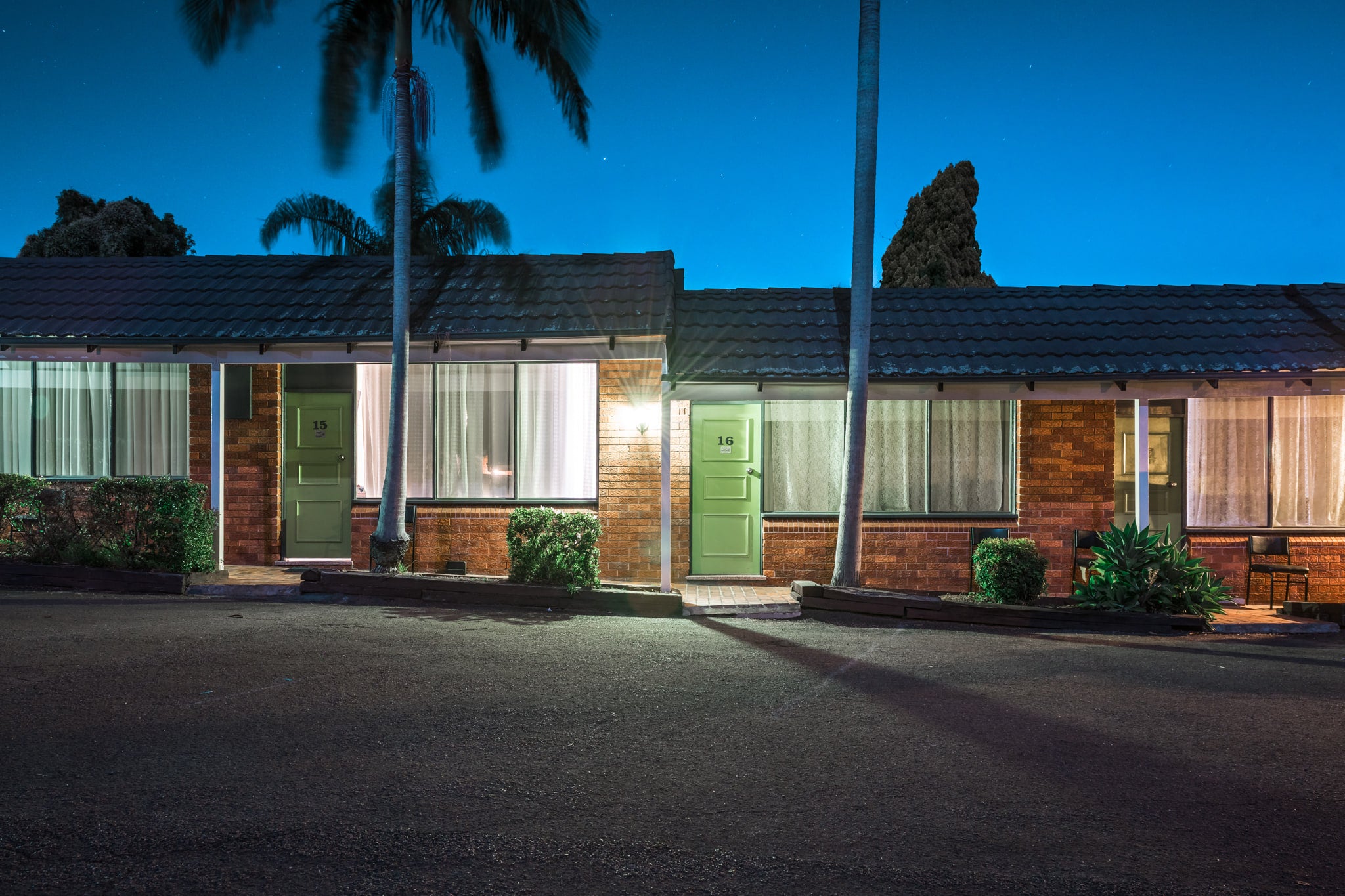 Town And Country Motel at Hotel Motel 101, brown brick units stretch in a low row beneath concrete tile roofing.