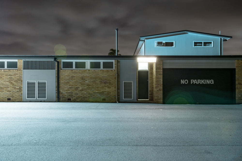 Twin Willows at Hotel Motel 101, a single floodlight burns above a narrow doorway, throwing cold white light.