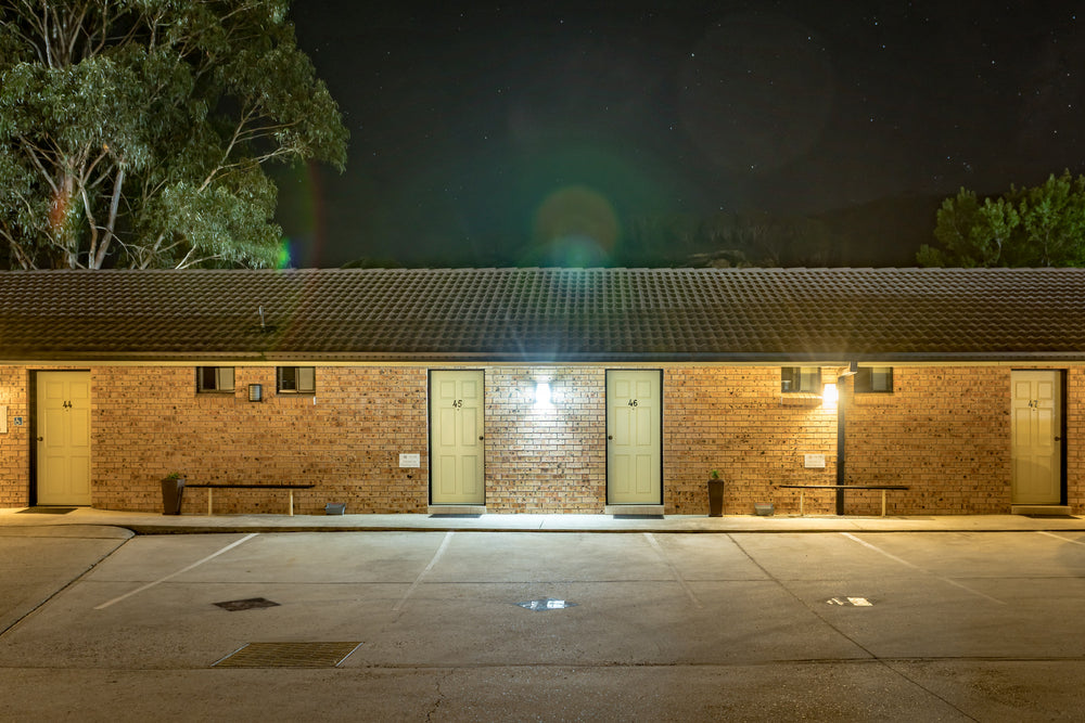 Zig Zag Motel at Hotel Motel 101, cream doors numbered 44 through 47 line a single-storey brown brick building.