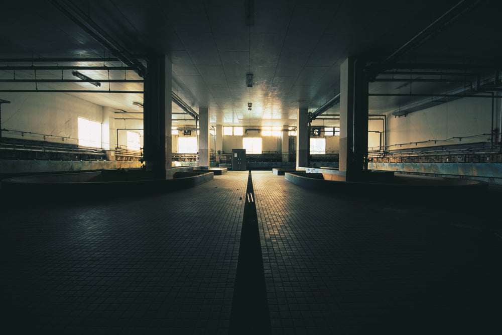 Pithead bath at Ikeshima Coal Mine, a drainage channel down the tiled floor between two sunken concrete baths.
