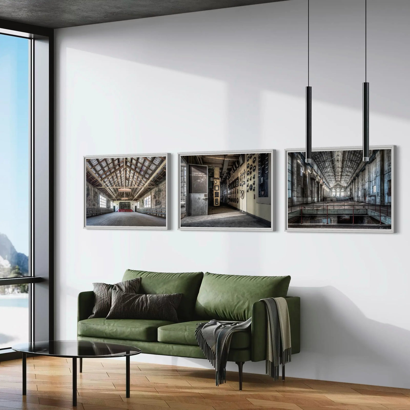 Set of three framed art prints featuring industrial architecture displayed above a green sofa in a contemporary living room.