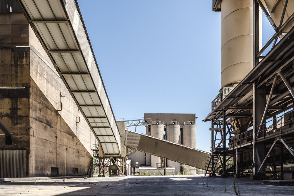 Top Of The Works at Kandos Cement Works, concrete walls rise several storeys on the left, stained dark with mineral residue.