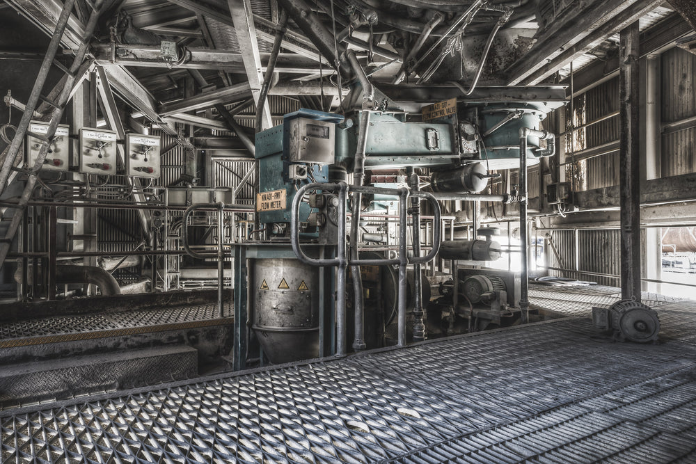 Weigh Feeder at Kandos Cement Works, steel grating covers the floor, its diamond-pattern surface worn dark withite dust.