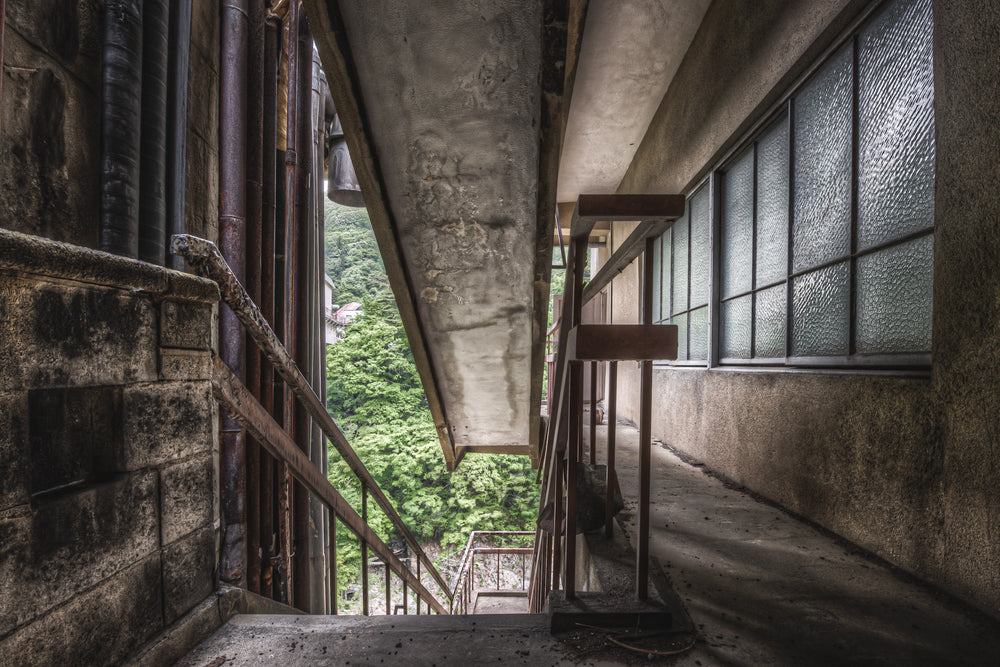Exterior Fire Exit at Kinugawa Kan, a concrete overhang presses low above an exterior corridor on the upper floors.