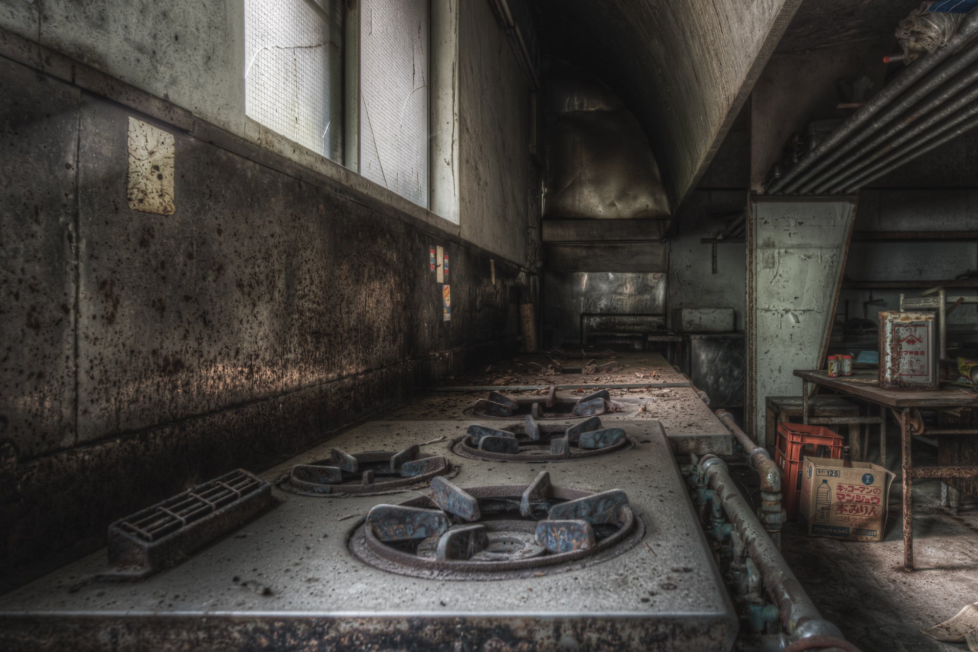 Stoves at Kinugawa Kan, a row of heavy-duty gas stoves sits coated in dust, their burners long extinguished.