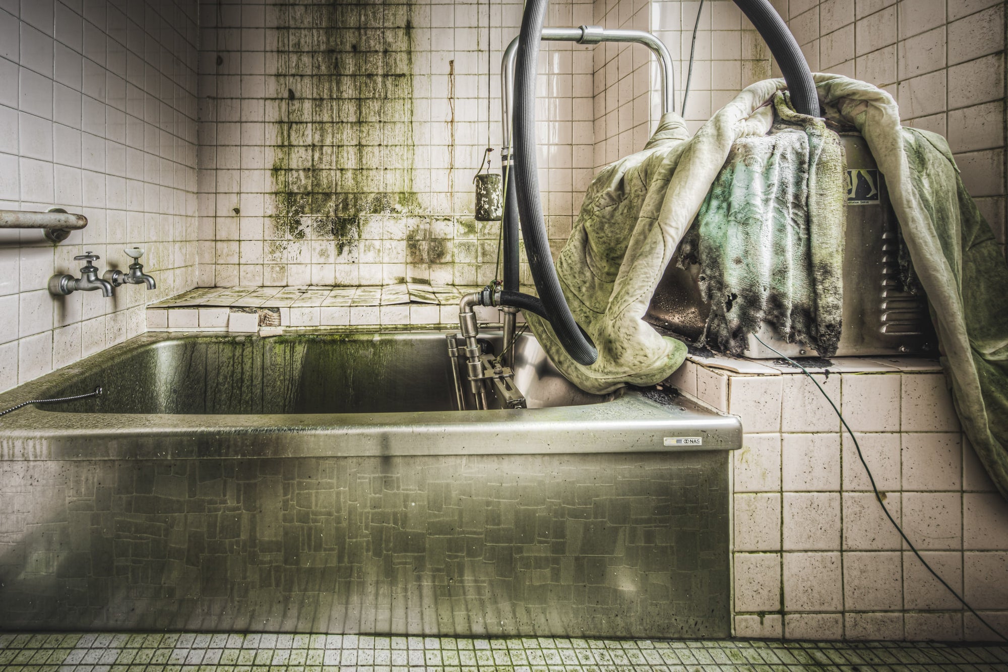Bath at Kuwashima Hospital, a stainless steel hydrotherapy bath sits recessed into a tiled platform.