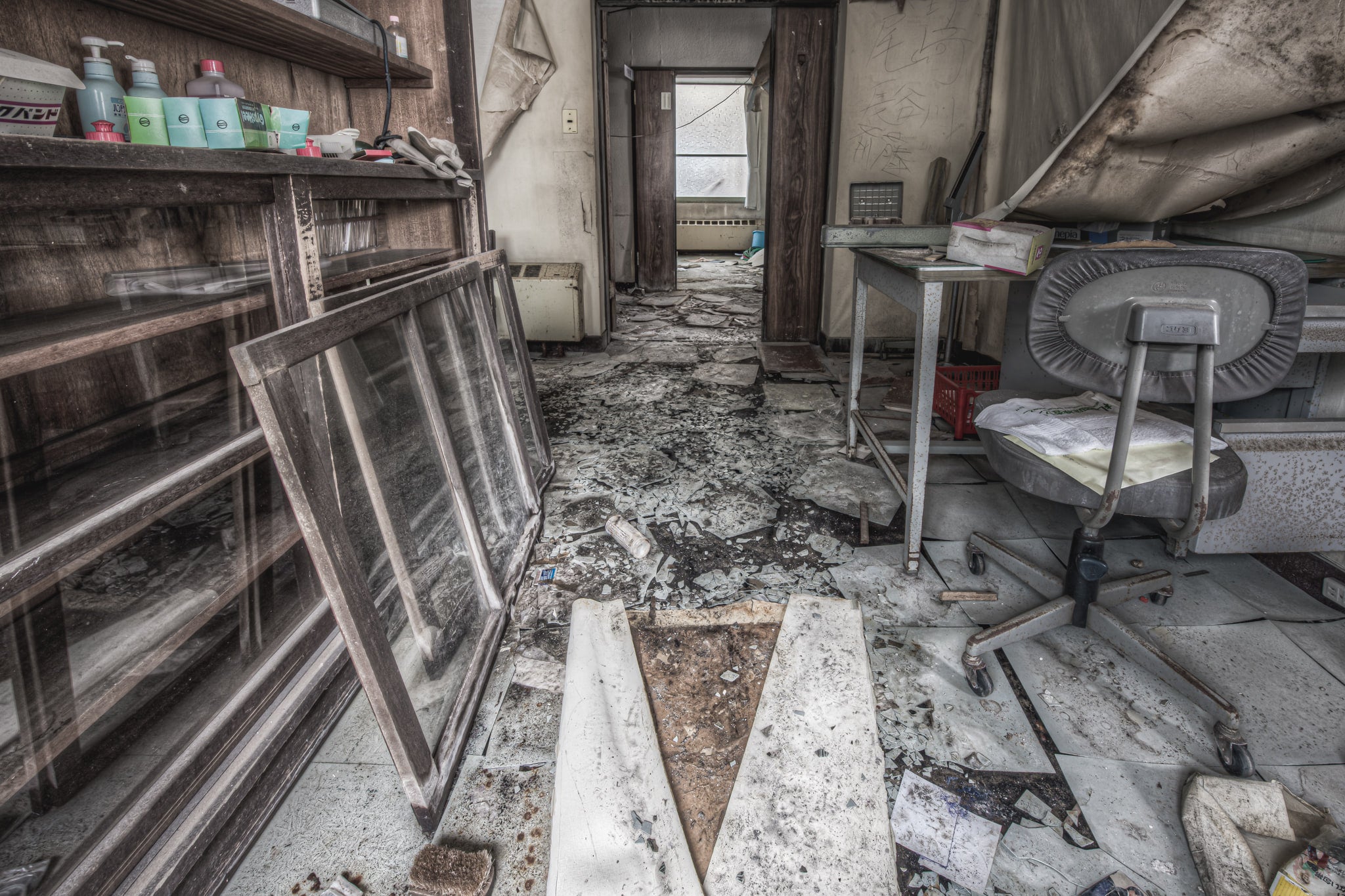 Chemical Storage at Kuwashima Hospital, a glass-fronted cabinet lines the left wall, its sliding panels removed and leaned.