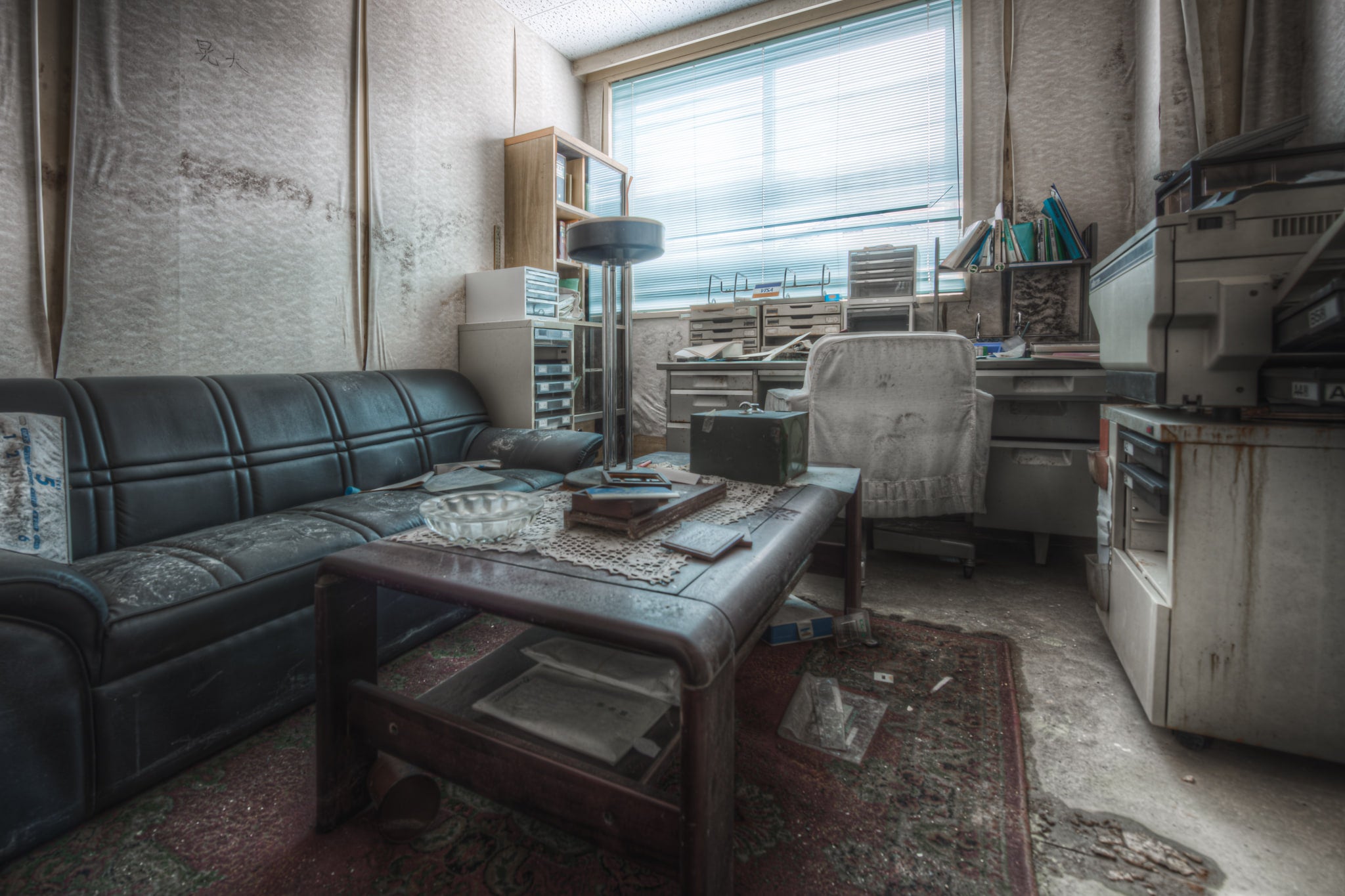 Doctors Office at Kuwashima Hospital, a dark blue vinyl couch sits against the far wall, its surface covered in a fine grey.