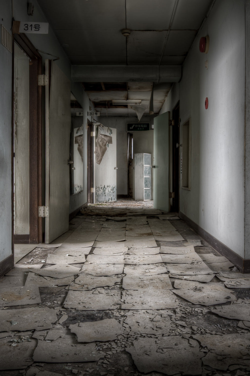 Hallway at Kuwashima Hospital, vinyl floor tiles have lifted and shattered across the corridor of Kuwashima Hospital's.