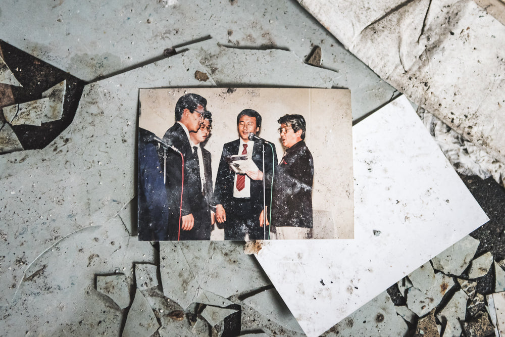 Karaoke Night at Kuwashima Hospital, a colour photograph lies face-up on a floor of shattered tiles.