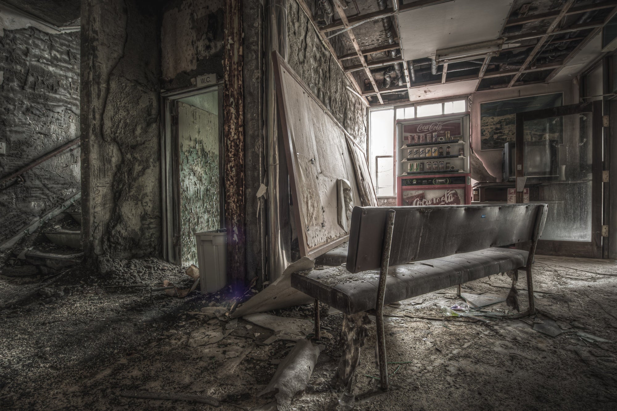 Waiting Room at Kuwashima Hospital, a vinyl bench sits in the centre of the ground-floor lobby, its chrome legs corroded.