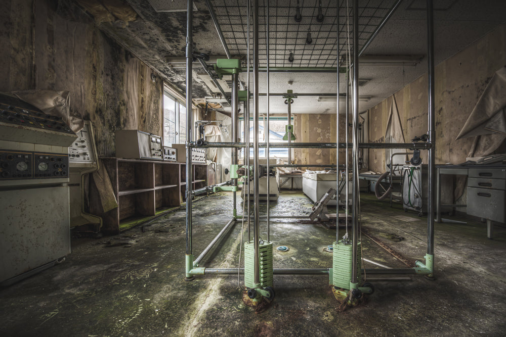 Weights at Kuwashima Hospital, a rehabilitation frame stands at the centre of the room, its green-painted castors rusted.