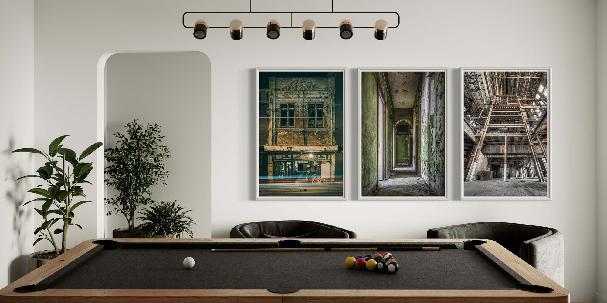 Landscape view of a modern pool room featuring three framed prints of abandoned buildings on the wall, showcasing unique architectural details and textures.