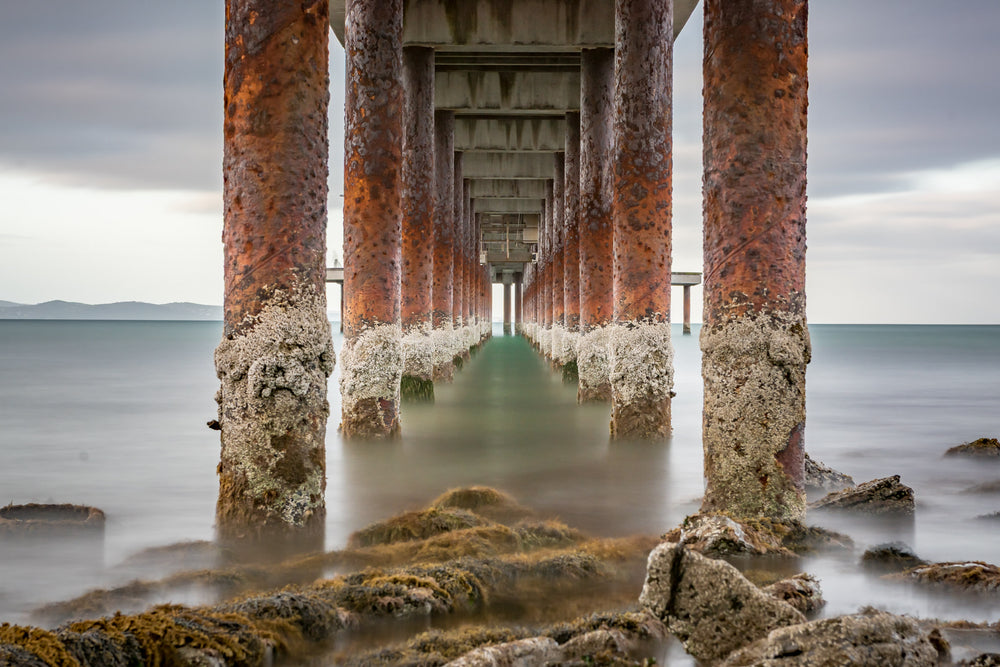 Lorne Pier at Landscapes, the barnacle-encrusted pylons of Lorne Pier extending off the shore.