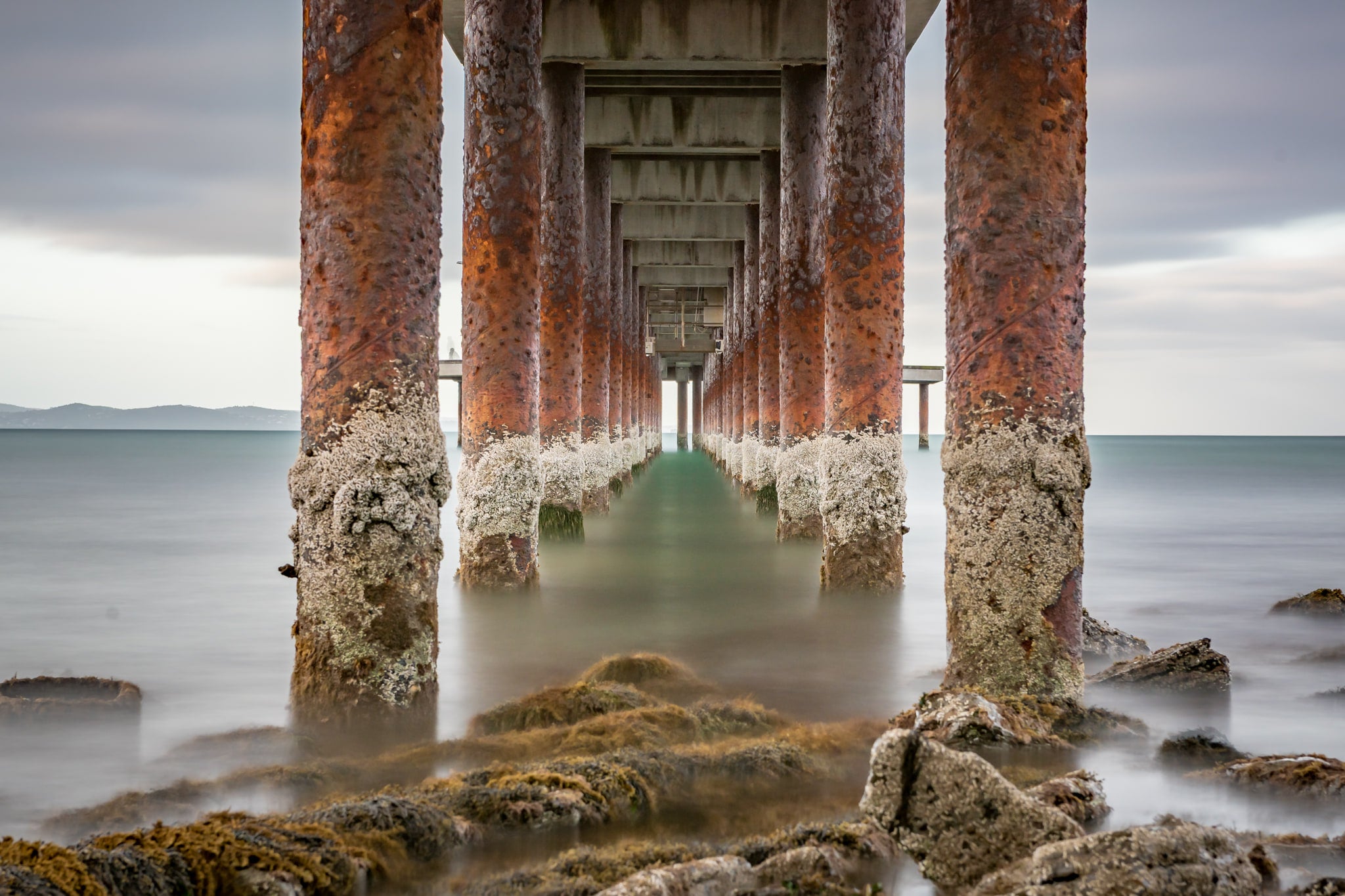 Lorne Pier at Landscapes, the barnacle-encrusted pylons of Lorne Pier extending off the shore.