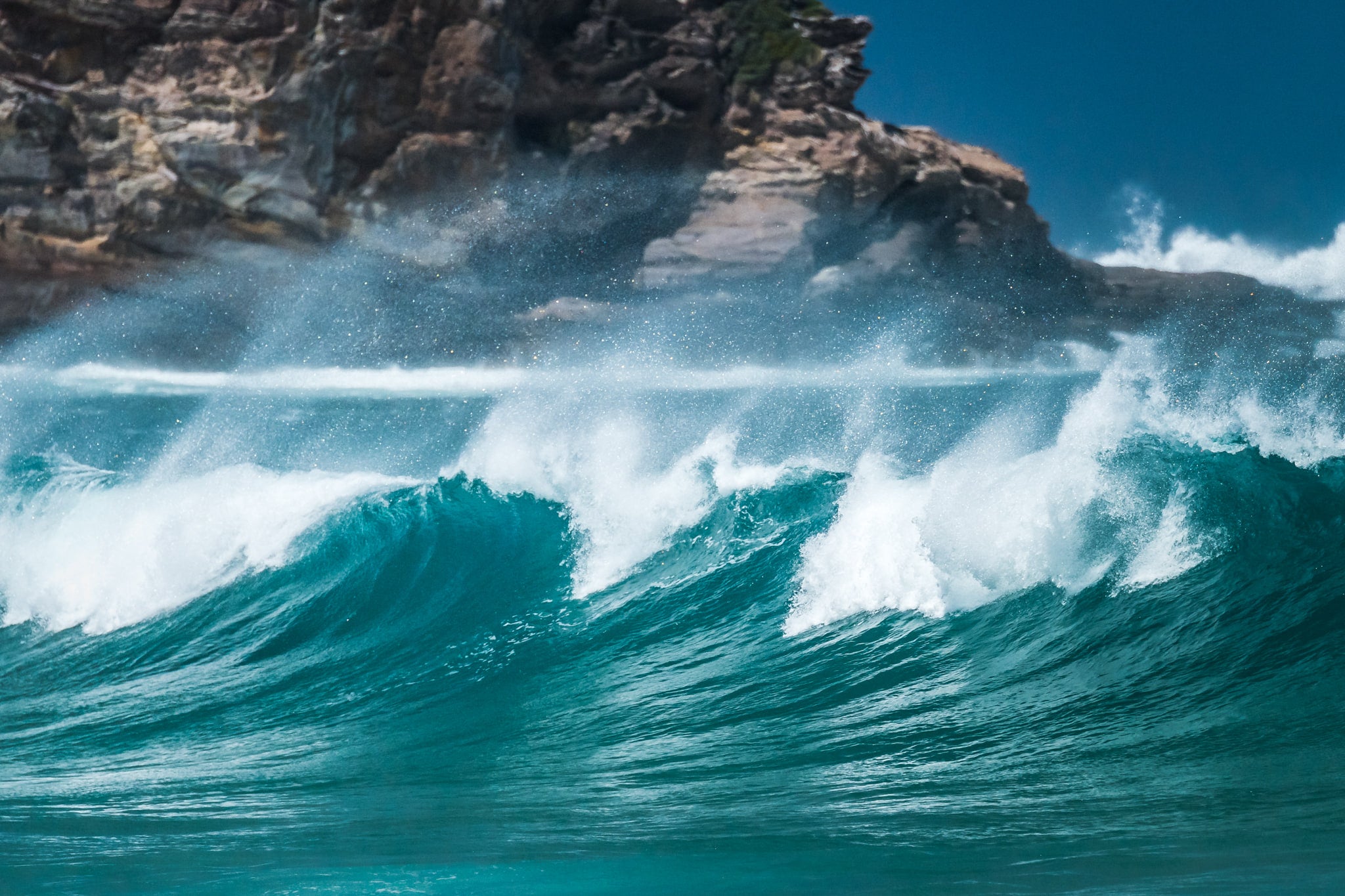 Tura Beach Waves at Landscapes, wild waves crash against a backdrop of the rocky cliff heads of Tura Beach.