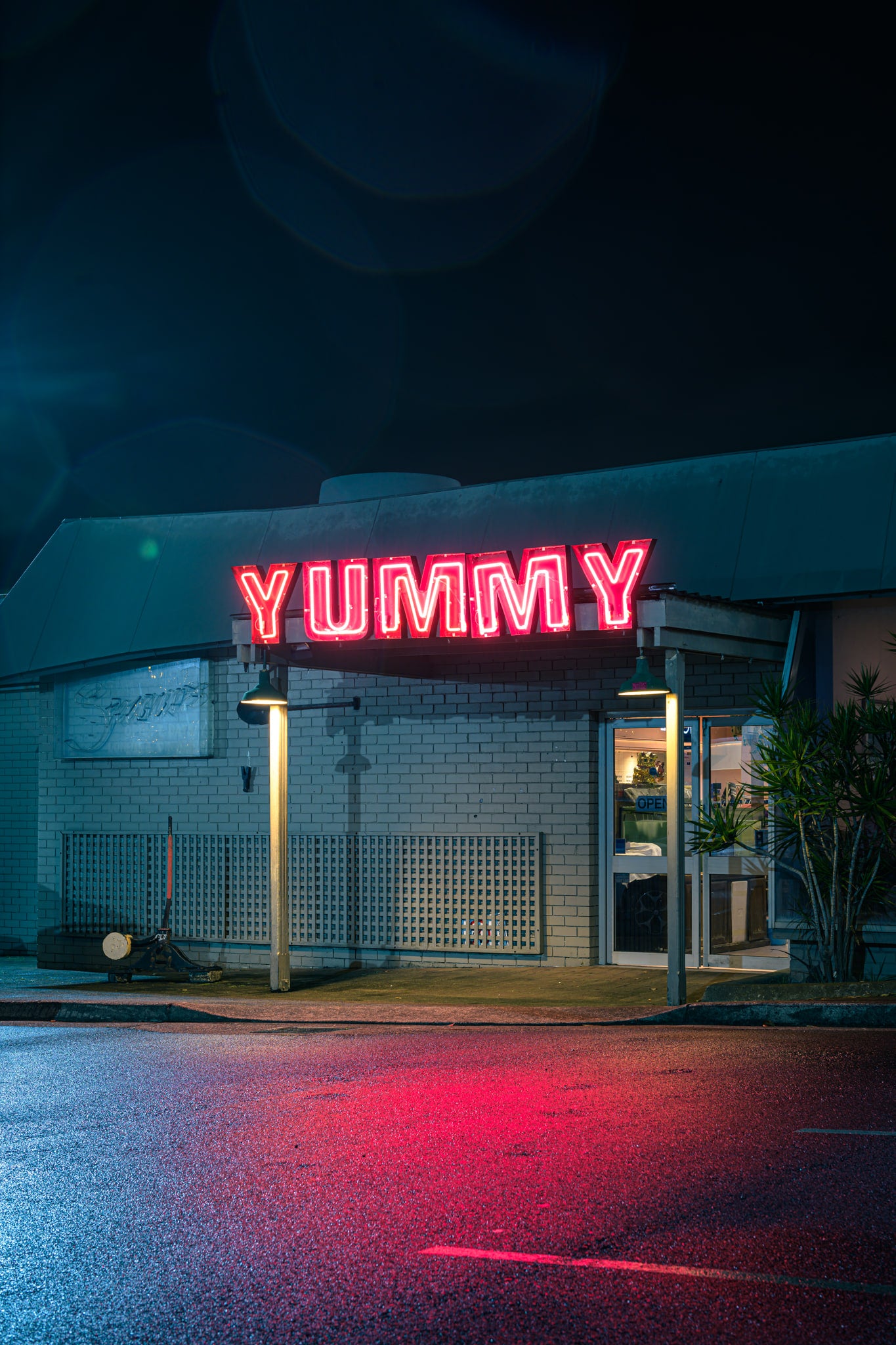 Yummy at Landscapes, red neon letters spell YUMMY across the flat roof of a single-storey brick shopfront.