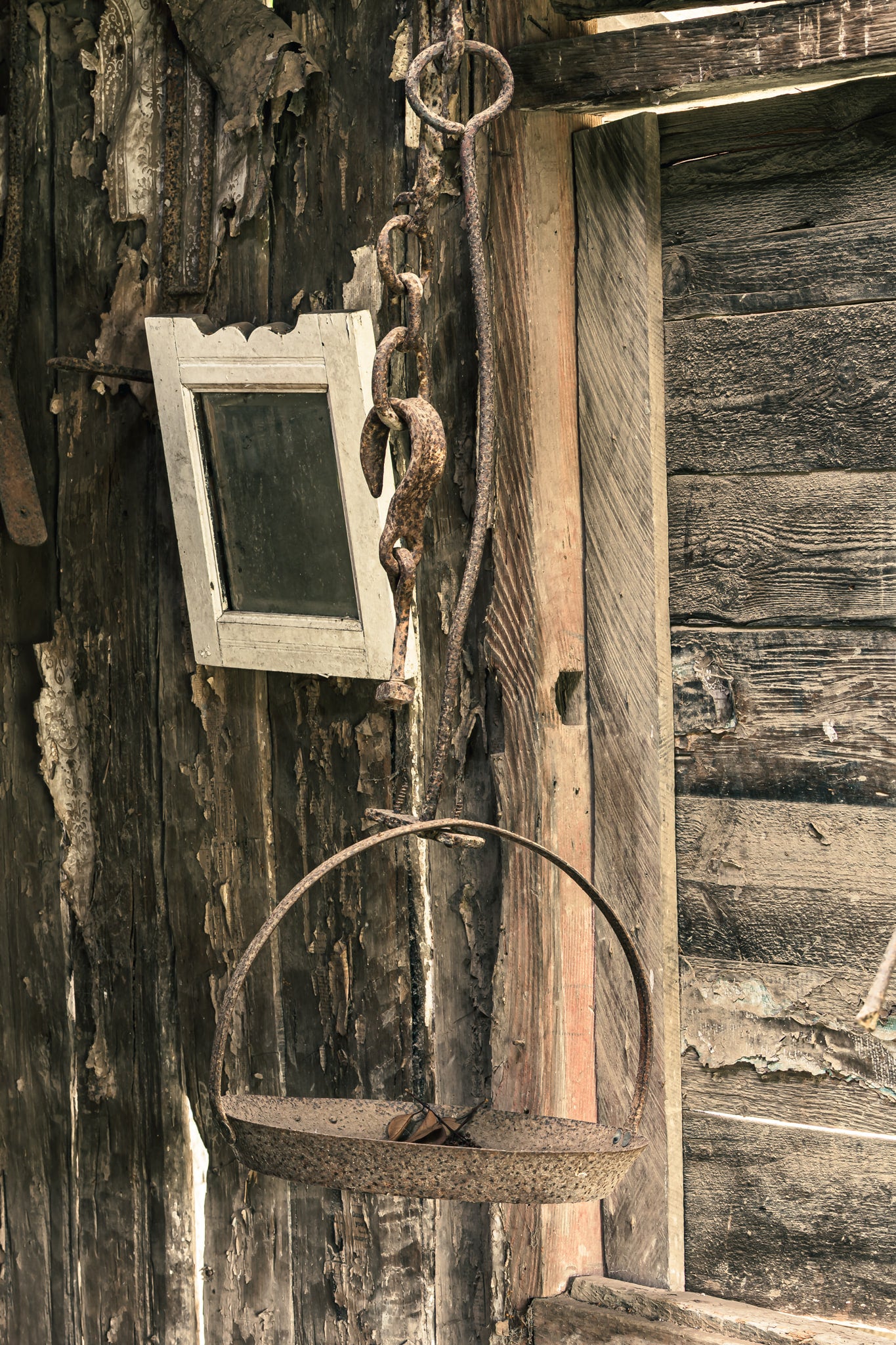 Hanging Scale at Leichhardt House, a rusted iron scale hangs from a heavy chain and ring bolt fixed to the exterior wall.