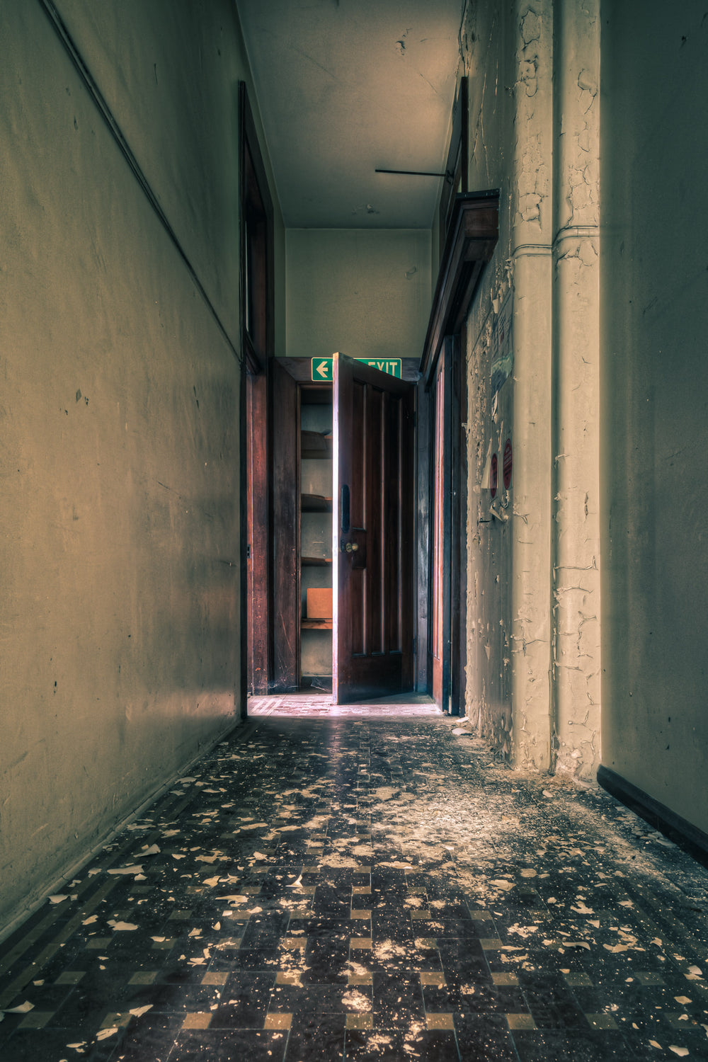 Exit at Lewisham Hospital, a narrow corridor leads to a heavy timber door, swung half open.