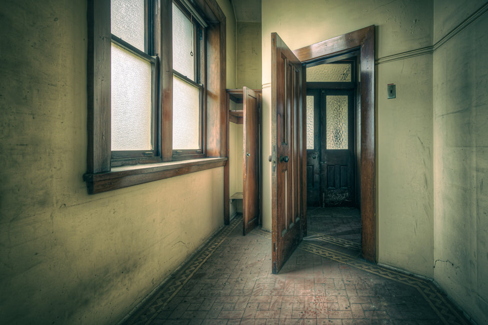 Storage at Lewisham Hospital, a narrow corridor leads to an open timber door.