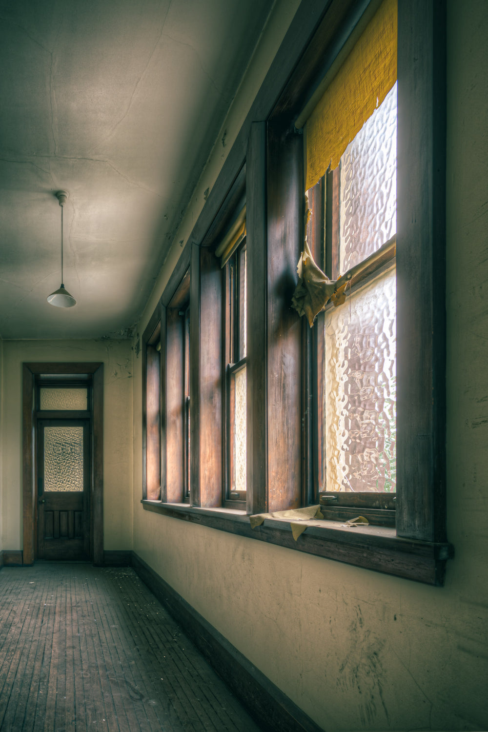 Torn at Lewisham Hospital, afternoon light presses through textured glass, warming the timber window frames to a deep amber.
