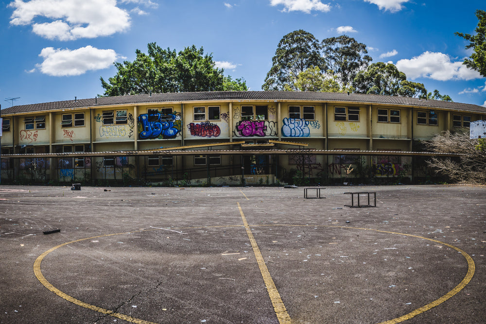 Basketball Court Panorama at Macquarie Boys Technology High, a two-storey classroom block curves around an empty basketball court.