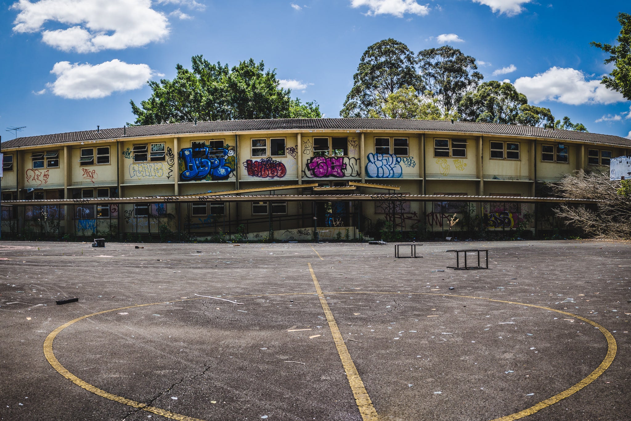 Basketball Court Panorama at Macquarie Boys Technology High, a two-storey classroom block curves around an empty basketball.