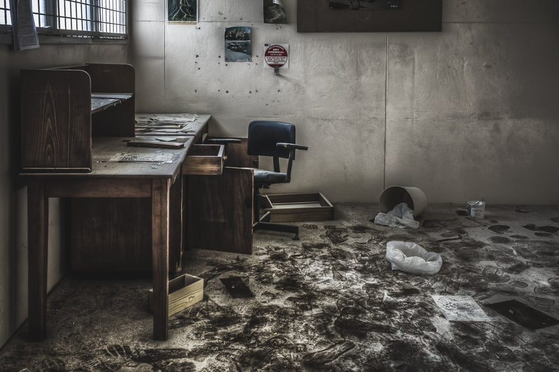 Dry powder coats the floor of a small room off the science block, settling over scattered papers, an overturned bucket, and a white plastic bag at Macquarie Boys Technology High.
