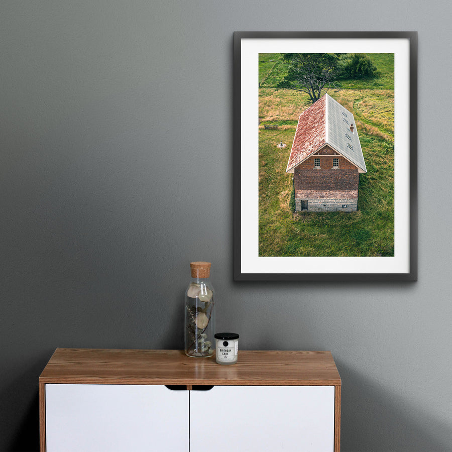 Pitched roof and brick gable at Jembaicumbene, copper and grey iron cladding with a brick chimney.