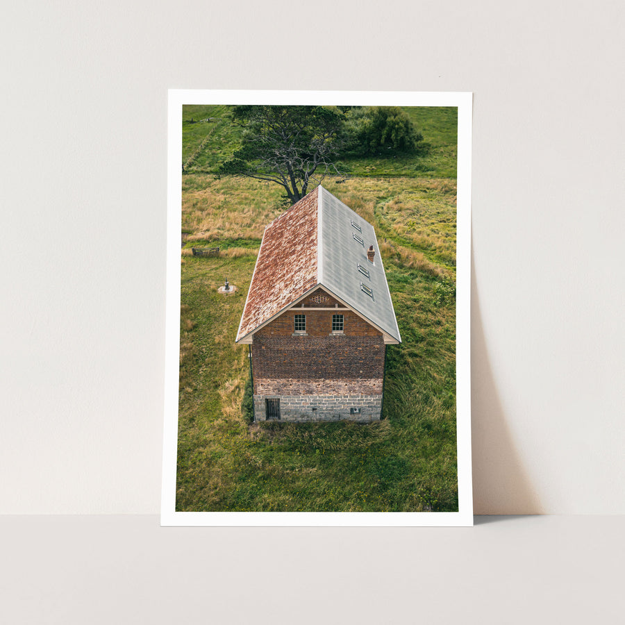 Pitched roof and brick gable at Jembaicumbene, copper and grey iron cladding with a brick chimney.