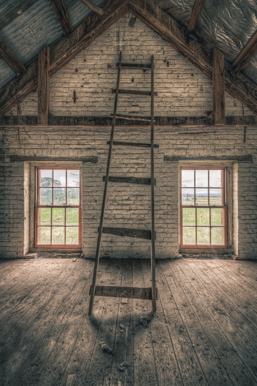 Top of the Mill at Mill Pond Farm, a timber ladder leans against the gable wall, its rungs cracked and splintered.