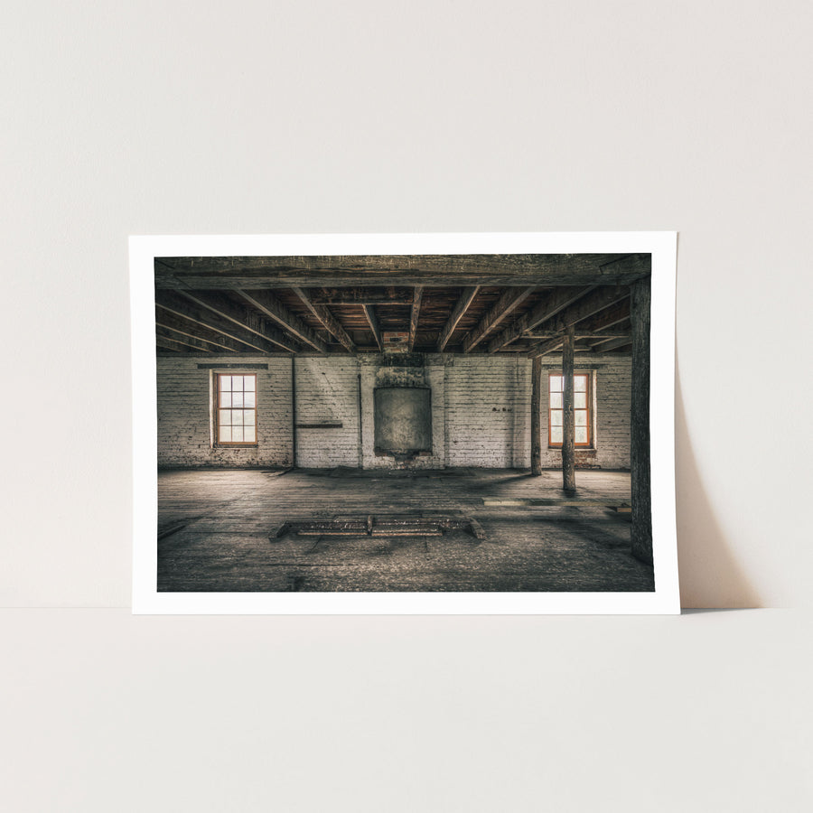 Upper room at Jembaicumbene mill, whitewashed brick walls and two sash windows over a bare timber floor.