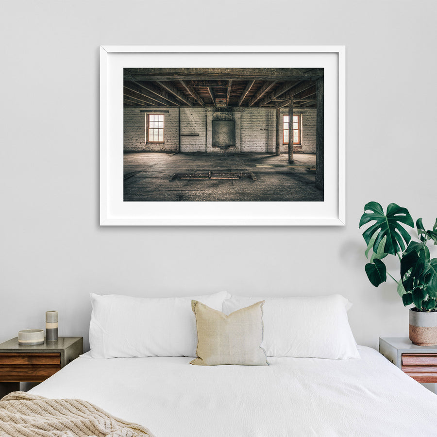 Upper room at Jembaicumbene mill, whitewashed brick walls and two sash windows over a bare timber floor.