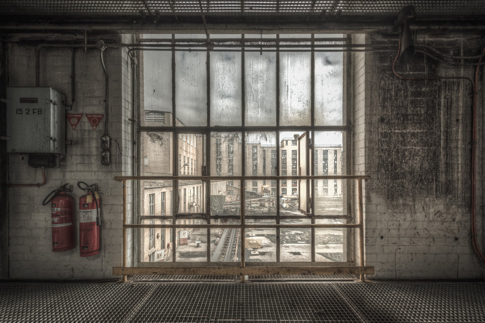 B to A at Morwell Power Station, a steel-framed window stretches floor to ceiling, divided into a grid of thick panes.
