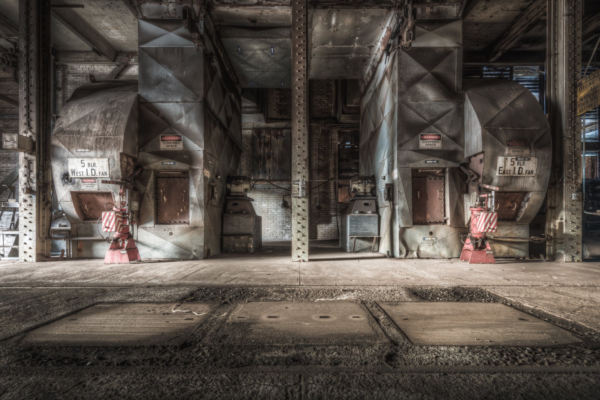 Blowers at Morwell Power Station, two induced-draft fans sit in mirrored bays either side of a riveted steel column.