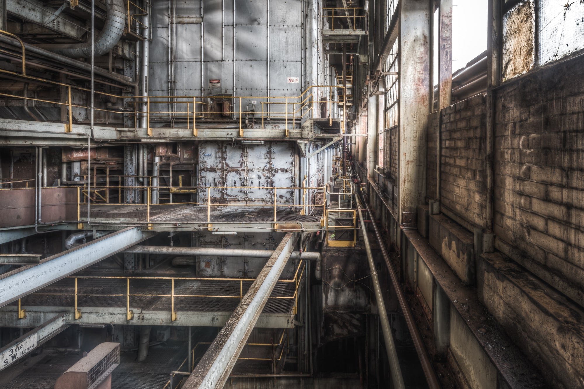 Boiler 3 at Morwell Power Station, yellow safety railings grid the space across multiple levels, steel grating underfoot.