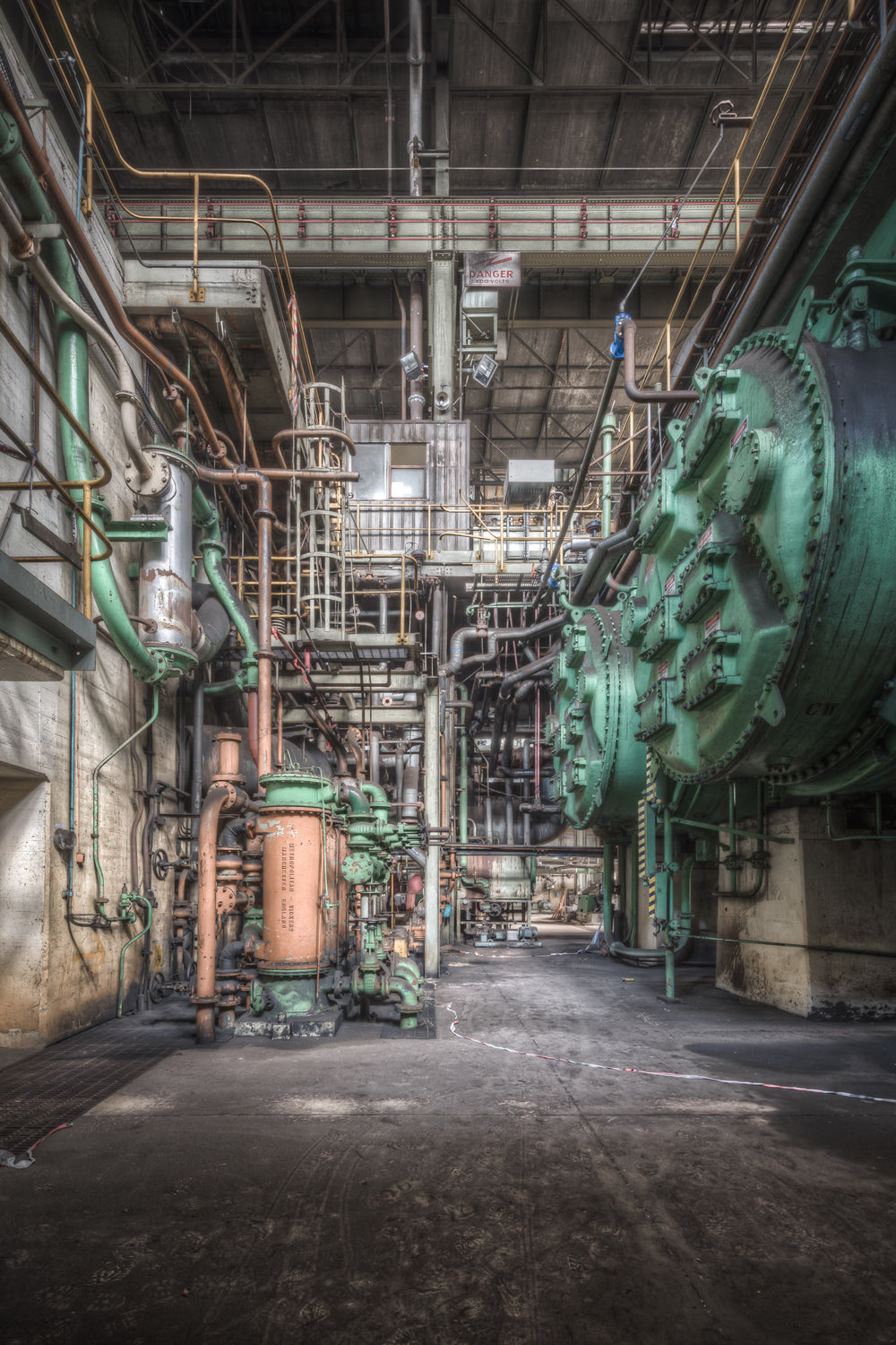 Condenser at Morwell Power Station, a massive green condenser drum dominates the right side of the frame, its bolted end.