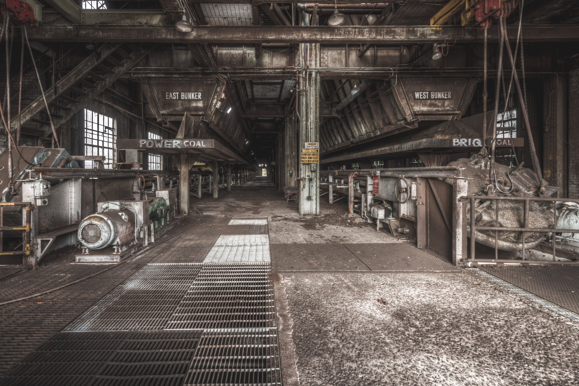 East and West at Morwell Power Station, steel coal bunkers hang overhead, labelled East and West.