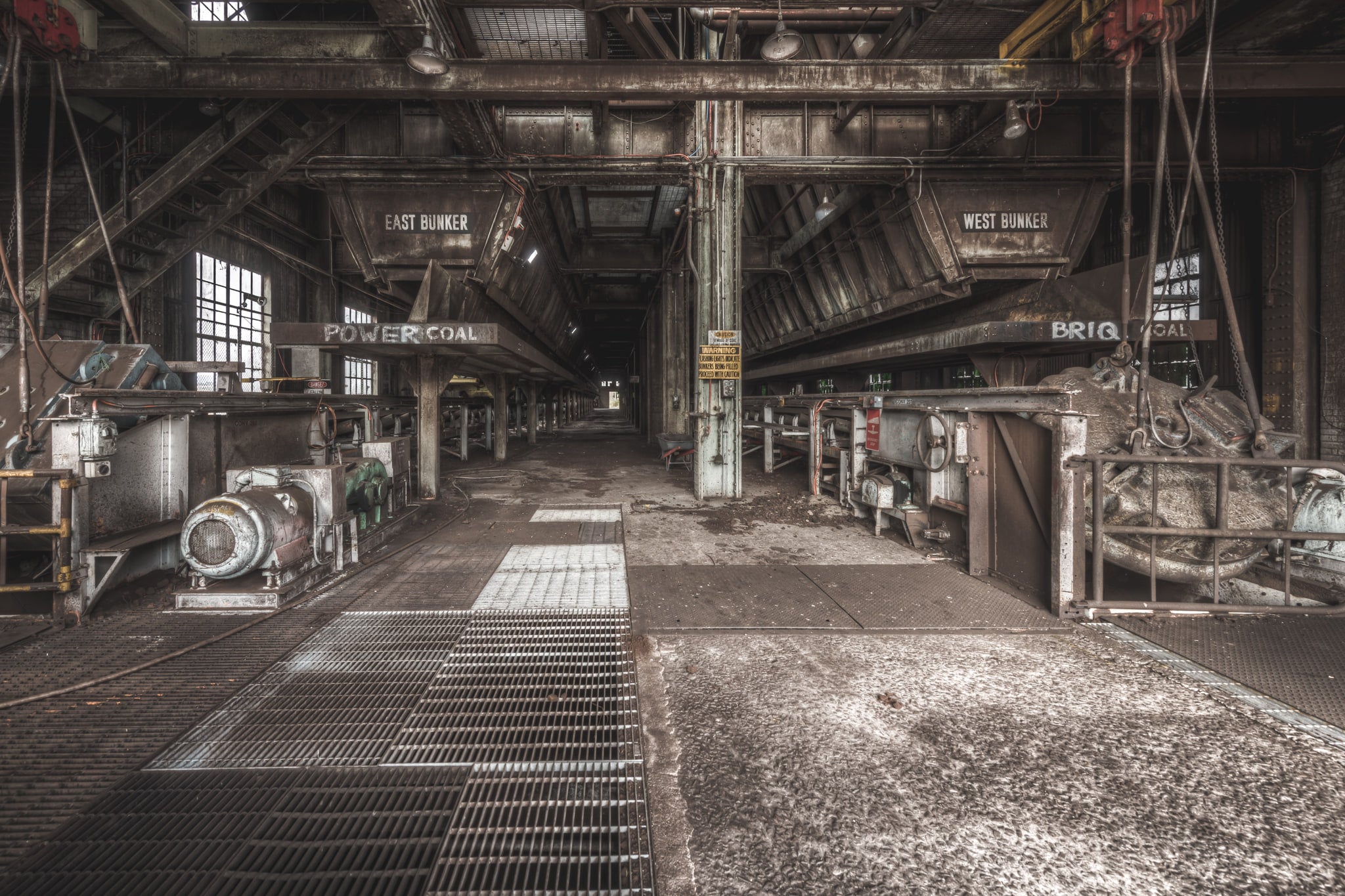 East and West at Morwell Power Station, steel coal bunkers hang overhead, labelled East and West.
