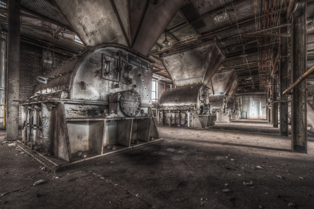 Hammer Mills at Morwell Power Station, a large industrial fan sits caged behind steel mesh on the right.