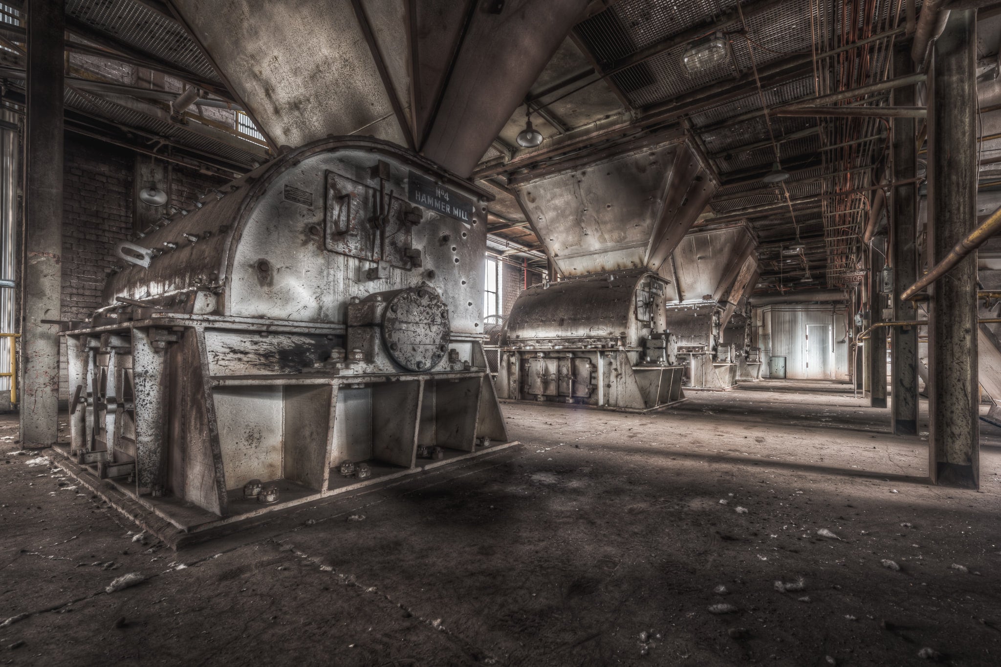 Hammer Mills at Morwell Power Station, a large industrial fan sits caged behind steel mesh on the right.