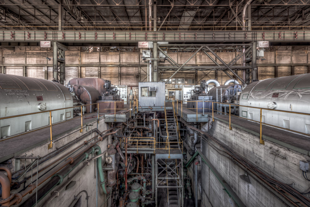 Turbine Floor at Morwell Power Station, four turbo-alternator units sit in two rows, their cylindrical steel casings grey.